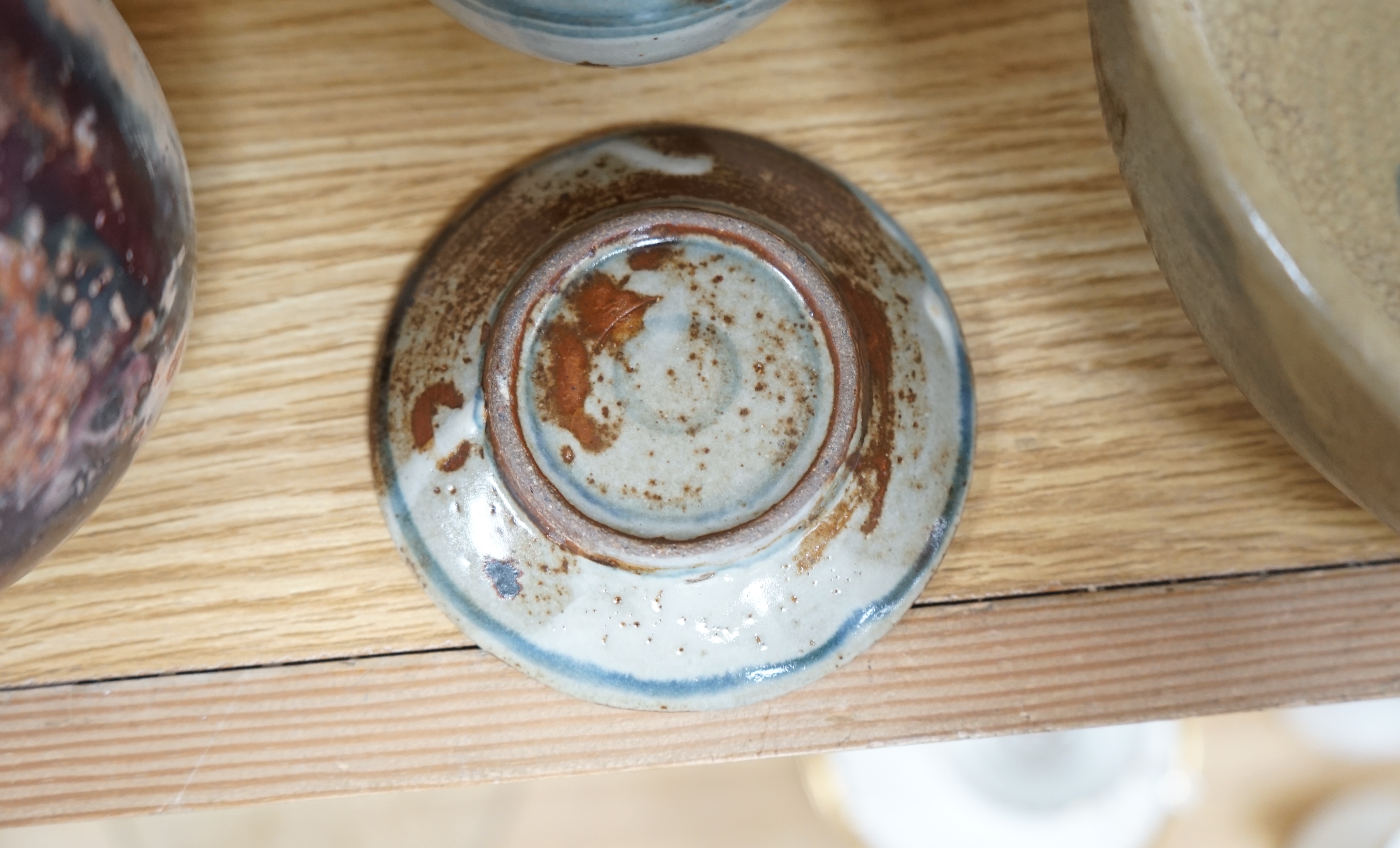 Three pieces of glazed studio pottery comprising a bowl, vase, and a cup and saucer by Seth Cardew, stamped to the base, largest 19cm in diameter. Condition - good